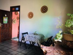 a room with a table and chairs and a red door at Pousada Morro Bello in Morro de São Paulo