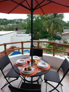 a table topped with a umbrella and a table cloth at Hotel y Suites Los Encantos in Sayulita