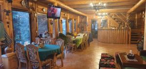 a dining room with a table and chairs and a tv at Cabana Ignis in Baia Mare