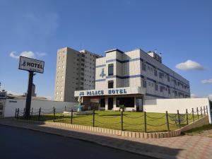 a large building with a sign in front of it at Js Palace Hotel in Alfenas