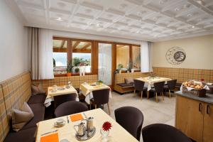 un restaurante con mesas y sillas en una habitación en Garni-Hotel Tritscherhof, en Tirolo