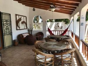 a porch with a table and chairs and a couch at Casa Playas in Playas