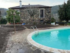 a swimming pool in front of a house at Casa do Adro-Passadiços do Paiva Arouca in Arouca