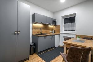 a kitchen and dining room with a table in a room at Apartmány Sendy in Ždiar