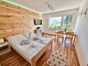 a bedroom with a bed and a dining room with a table at Apartamenty Willa NaSkarpie Jacuzzi Sauna Basen in Wisła