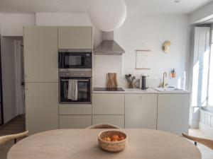 una cocina con una mesa con un bol de fruta. en L'ORANGERAIE Appartement design en plein centre en Castres