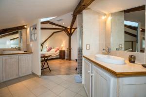 a bathroom with a sink and a room with a couch at Chambre d'Hôtes Bastide du Cosset in Barcelonne-du-Gers +33 photos