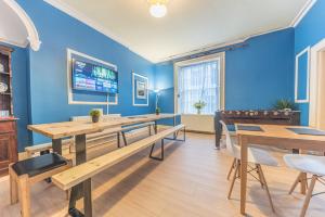 a dining room with blue walls and wooden tables at Tivoli Guesthouse in Whitehaven
