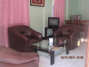 een woonkamer met 2 lederen stoelen en een salontafel bij Jared Suites in Upper Digos