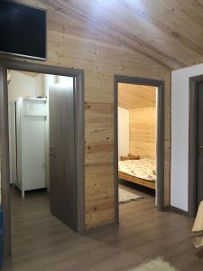 Zimmer mit einer Tür, die zu einem Schlafzimmer führt in der Unterkunft La cabana in Ocnele Mari