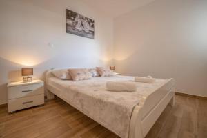 1 dormitorio con 1 cama con 2 almohadas en Apartman Mila Zivogosce, en Živogošće