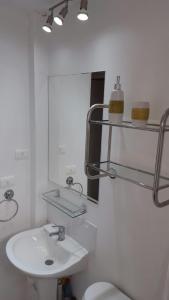 ein Badezimmer mit Waschbecken, Toilette und Spiegel in der Unterkunft Departamento Marina la Serena in La Serena