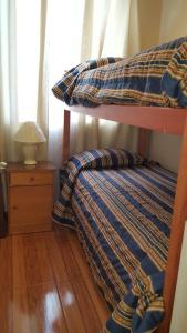 ein Bett mit einer karierten Bettdecke darauf in der Unterkunft Departamento Marina la Serena in La Serena + 23 Fotos