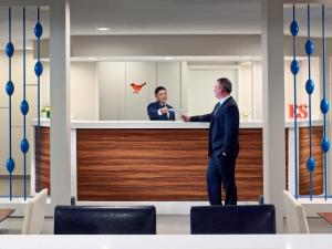 a man in a suit standing at a counter at Sonesta ES Suites St. Louis - Chesterfield in Chesterfield