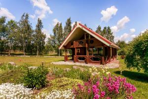 eine Hütte inmitten eines Feldes mit Blumen in der Unterkunft Resort by Nava Lake in Aukštadvaris