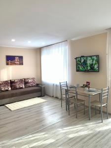 a living room with a table and a couch at Бам. Вул. Лепкого. 1-кімнатна. Студія. Новобудова in Ternopilʼ