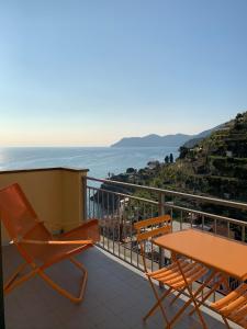 a balcony with a table and chairs and the ocean at Orizzonti Apartments in Manarola