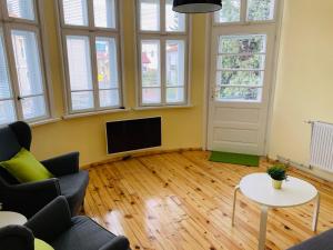 un soggiorno con TV, divano e tavolo di TÁNIN HOUSE - Three-bedroom apartment, sauna and gym 10' away from Borovets a Samokov