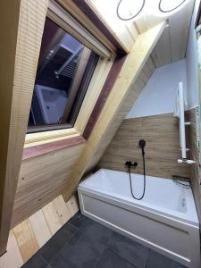 a bathroom with a bath tub and a window at Cabana NOR in Bistricioara