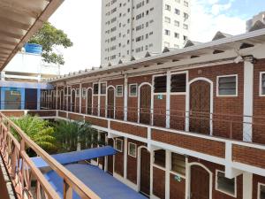 a balcony view of a brick building with a blue bench at Hotel Js in Alfenas