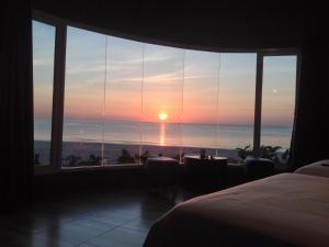 a room with a bed and a view of the ocean at Ban Tawansongfa in Lang Suan