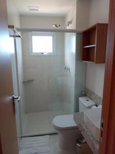 uma casa de banho com um chuveiro, um WC e um lavatório. em Salinas Exclusive Resort 24 em Salinópolis