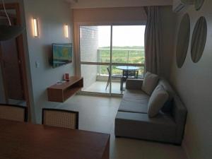 a living room with a couch and a table and a window at Salinas Exclusive Resort 24 in Salinópolis