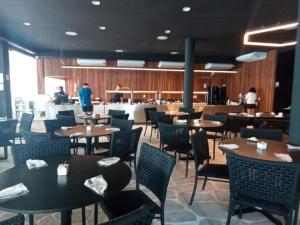 a dining room with tables and chairs and a bar at Salinas Exclusive Resort 24 in Salinópolis