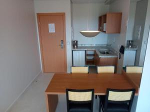 uma cozinha com uma mesa de madeira e cadeiras em Salinas Exclusive Resort 24 em Salinópolis