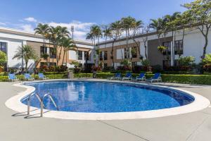 a swimming pool with chairs and a building at Holiday Inn Express San Jose Costa Rica Airport by IHG in Alajuela City