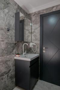 ein Bad mit einem Waschbecken und einer schwarzen Tür in der Unterkunft Ruby in Istanbul