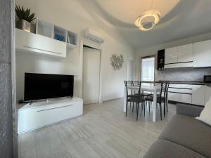 Una sala de estar con televisión y un comedor. en Villa Stella Marina, en Valledoria