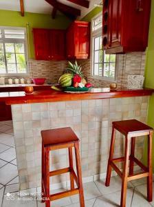 eine Küche mit roten Schränken und einem Obstteller in der Unterkunft La Marie-Galantaise dans la nature in Beaurenom