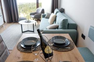 ein Tisch mit einer Flasche Wein und Gläsern darauf in der Unterkunft Vila Planinsko Blago in Kopaonik + 69 Fotos