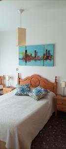- une chambre avec un lit en bois et 2 oreillers dans l'établissement Alojamiento Entradita Cazorla, à Cazorla