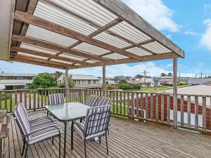 a patio with a table and chairs on a deck at Ambience By The Sea in Port Fairy