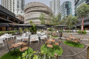 an outdoor restaurant with tables and chairs and umbrellas at Novotel Sydney Darling Square in Sydney