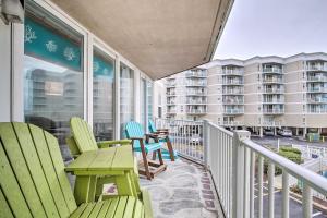 a balcony with chairs and tables and a building at Colorful Beachfront Condo with Resort Amenities in North Topsail Beach