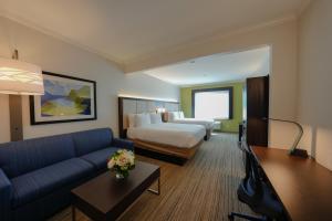 Holiday Inn Express Hotel & Suites Santa Clara - Silicon Valley, an IHG Hotel في سانتا كلارا: غرفه فندقيه بسرير واريكه