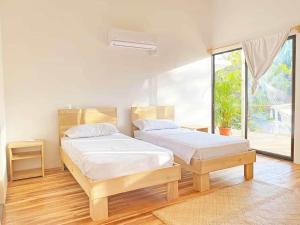 Un dormitorio con dos camas y una gran ventana. en La Sana Surf Hotel, New design, Few mn drive to the beach, en Santa Teresa Beach 108 fotos más