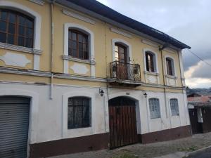 un edificio blanco y amarillo con una puerta en CASA VIEJA del Centro Historico, en Quito