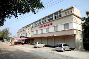 昆达普拉Fortune Village Hotel的两辆汽车停在一栋建筑物前
