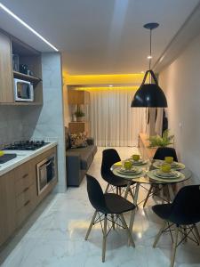 a kitchen and a living room with a table and chairs at Makambira Residence By SummerFlats no CENTRO DE PORTO DE GALINHAS in Porto De Galinhas