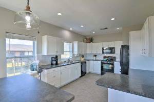 Una cocina con gabinetes blancos y una ventana grande. en West Galveston Home about Steps from Terramar Beach!, en Galveston