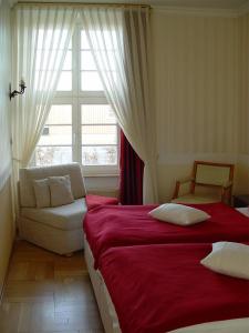 um quarto com uma cama, um sofá e uma janela em Hotel Altes Hafenhaus em Rostock