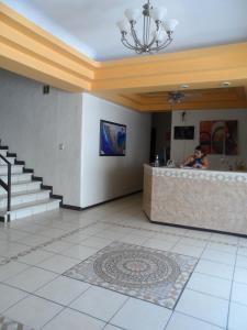 a lobby with a woman standing at a counter at Hotel Fernando in Tuxtla Gutiérrez