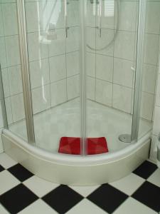 um chuveiro com um assento vermelho na casa de banho em Hotel Altes Hafenhaus em Rostock