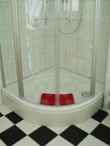 a shower with a red seat in a bathroom at Hotel Altes Hafenhaus in Rostock +20 photos