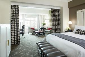 ボストンにあるHotel Commonwealthのベッドとリビングルームが備わるホテルルームです。