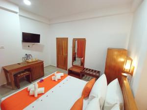 a bedroom with a bed and a television in it at Three Elephant Holiday Inn in Sigiriya